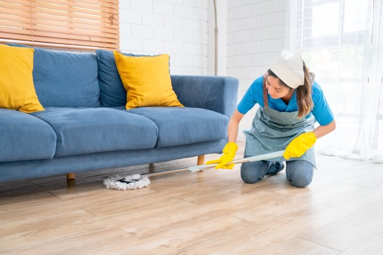 woman-cleaning-hardwood-floor-in-yellow-protective-2026-01-08-06-32-27-utc